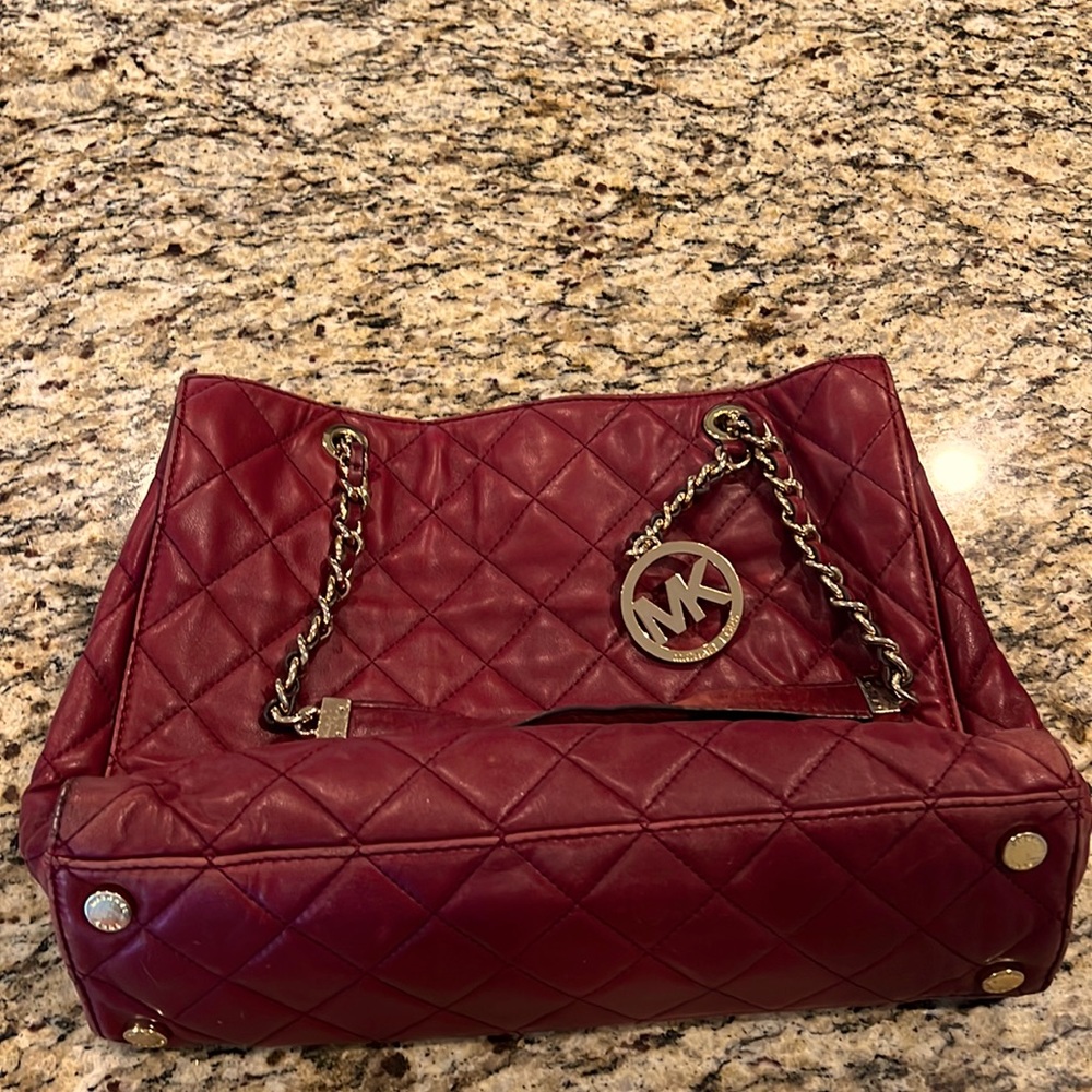 Burgundy with gold accent Michael Kors purse.